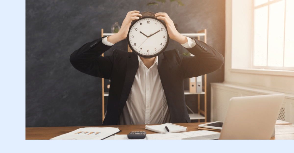 Picture of man at a desk with a clock for a face. Calendar creep 2.0!